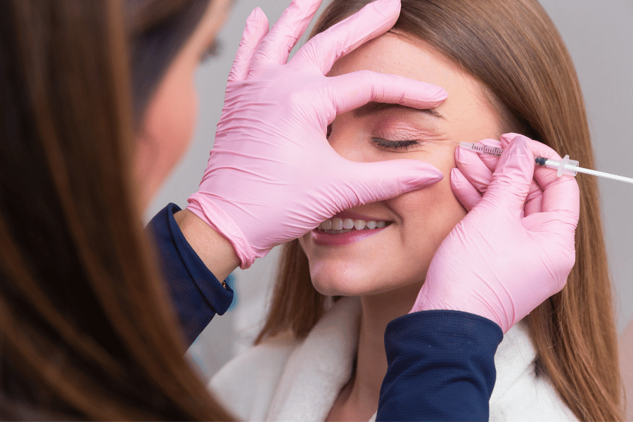 Woman receiving a cosmetic facial injection near her eye